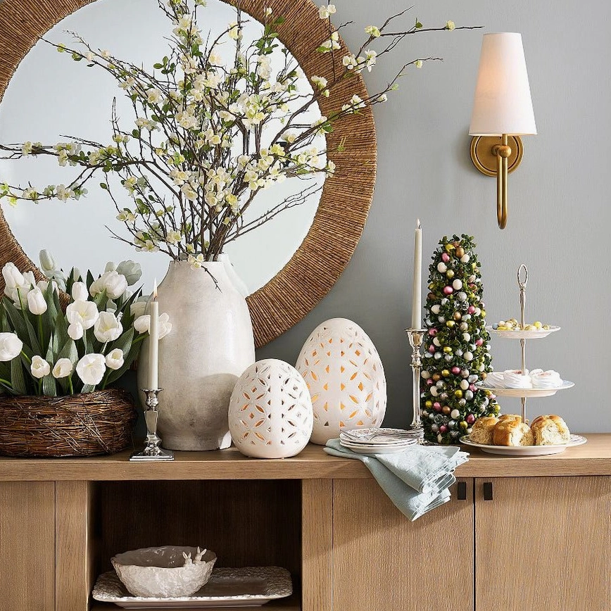 Pair of Farlane brass wall sconces flanking console table with mirror and floral arrangement