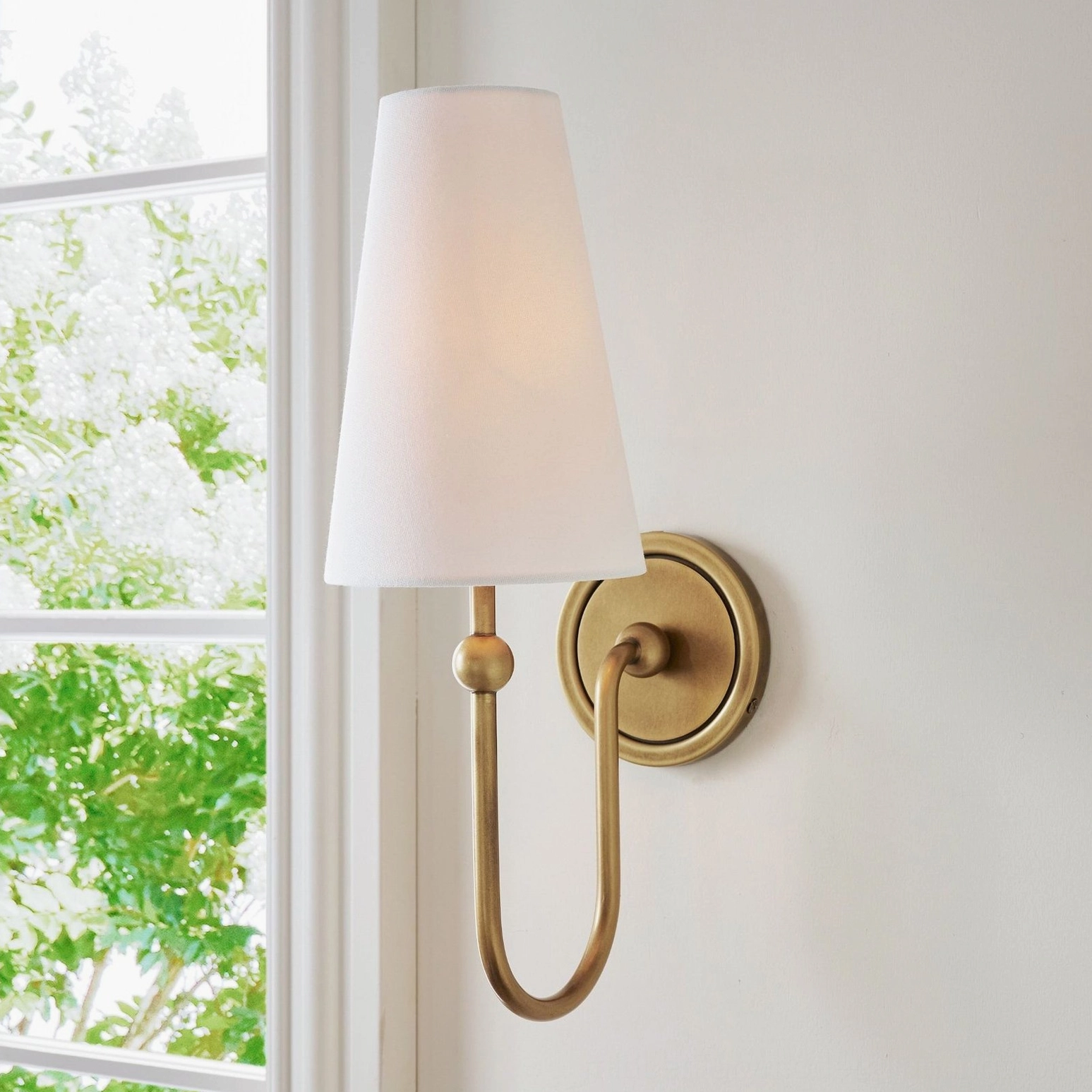 Farlane wall sconce installed by window in modern home interior with natural light