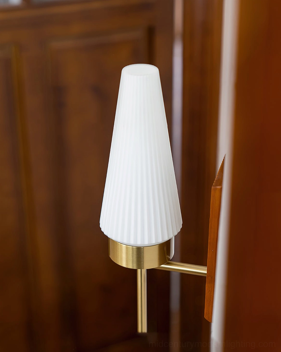 Farrell wall light frontal close-up showing vertical ribbed wooden backplate and brass screw fasteners