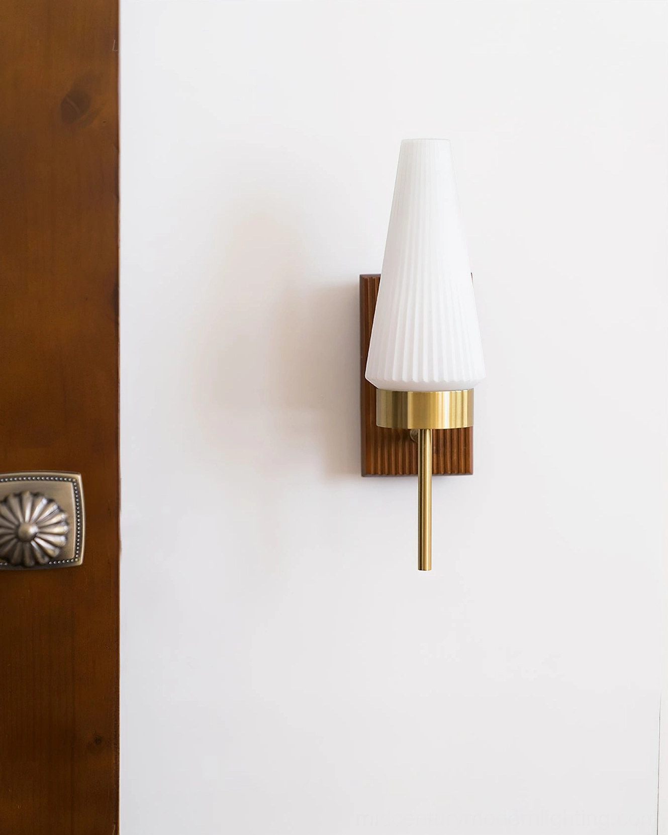 Farrell wall sconce angled side view showing tapered fluted white glass and brass gold hardware accents