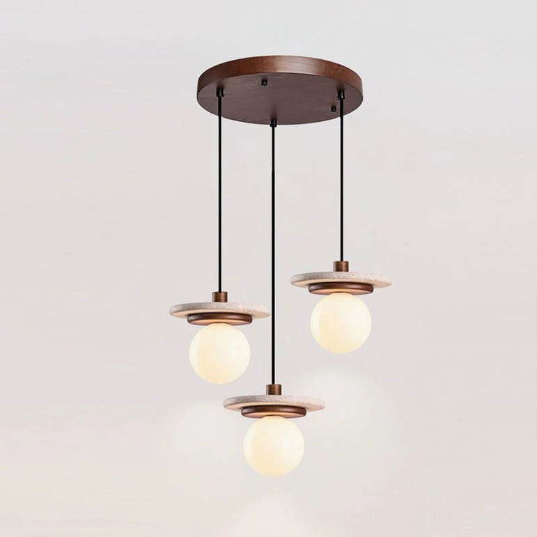 Three travertine pendant lights clustered on round canopy installation above round dining table