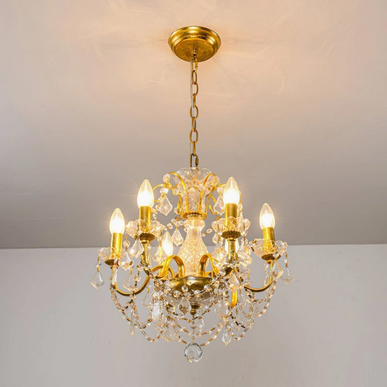 Lit Fauna crystal chandelier with gold metal frame mounted indoors, demonstrating soft warm glow and optical light distribution