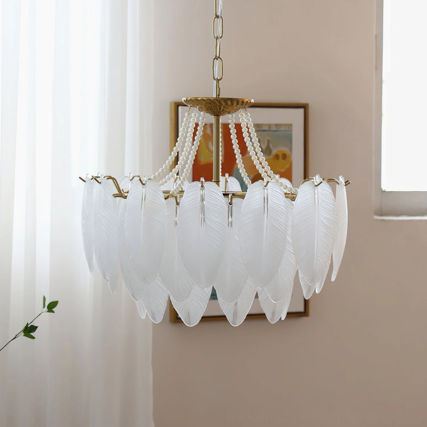 Feathered glass chandelier front view showing beaded decorative chains and vintage brass top mount with sheer window and framed wall art in background