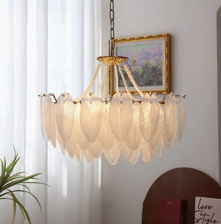 Feathered glass chandelier installed in vintage-inspired living room with sheer curtains, framed wall art, and green plants, demonstrating interior styling