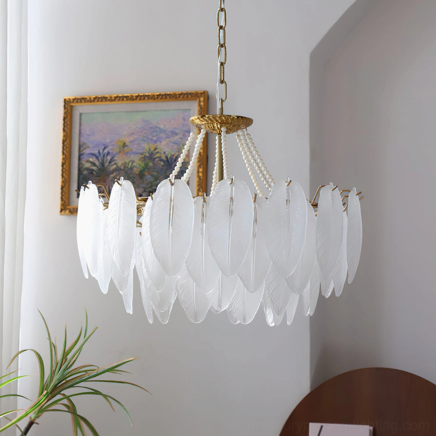 Left side view of feathered glass chandelier with pure bright white frosted glass shades in minimalist home corner with framed painting and green plant