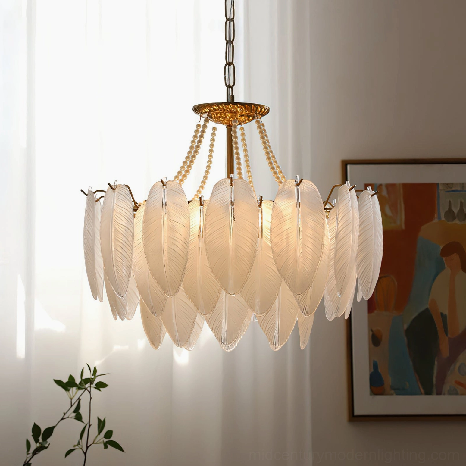Feathered glass chandelier in warm interior lighting with tan-toned glass shades, natural sunlight, sheer curtains, and wall artwork display