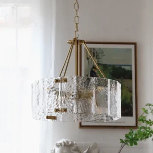 Mid-century modern Fenoullet chandelier installed in vintage-inspired living room with landscape wall art and potted plants