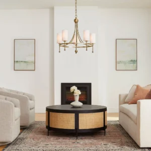 Fenwick brass gold chandelier installed in modern living room with fireplace, warm elegant lighting ambiance