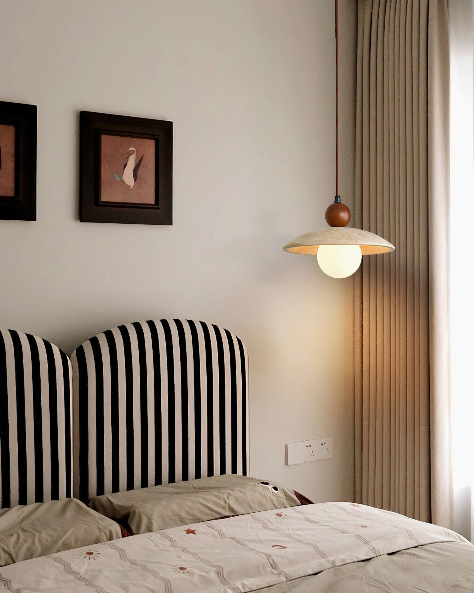 Ferox travertine pendant installed in retro bedroom with striped headboard, warm ambient lighting