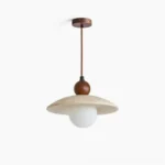 Ferox travertine pendant light with frosted opal globe - front oblique studio view showing beige stone disc shade and walnut wood hardware