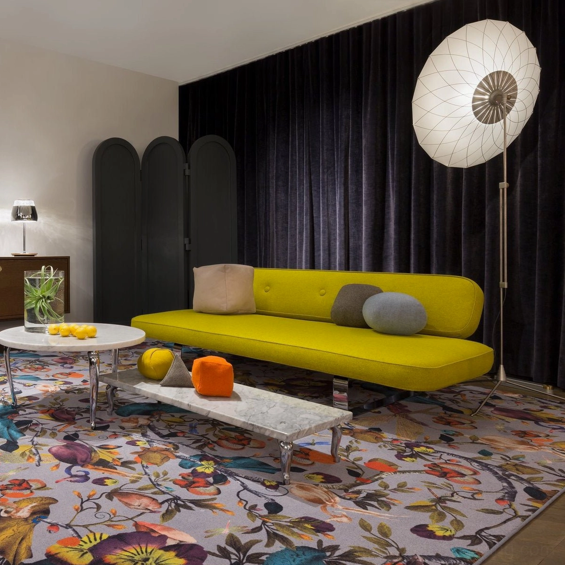 Filigree floor lamp in luxury contemporary living room with yellow velvet sofa and dark floor-to-ceiling curtains