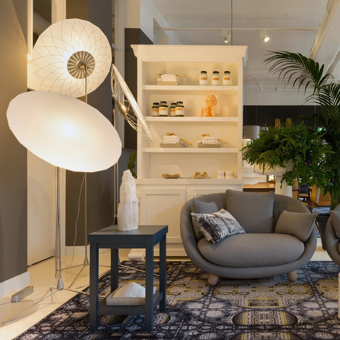 Pair of filigree floor lamps in modern home interior with white shelving and patterned area rug