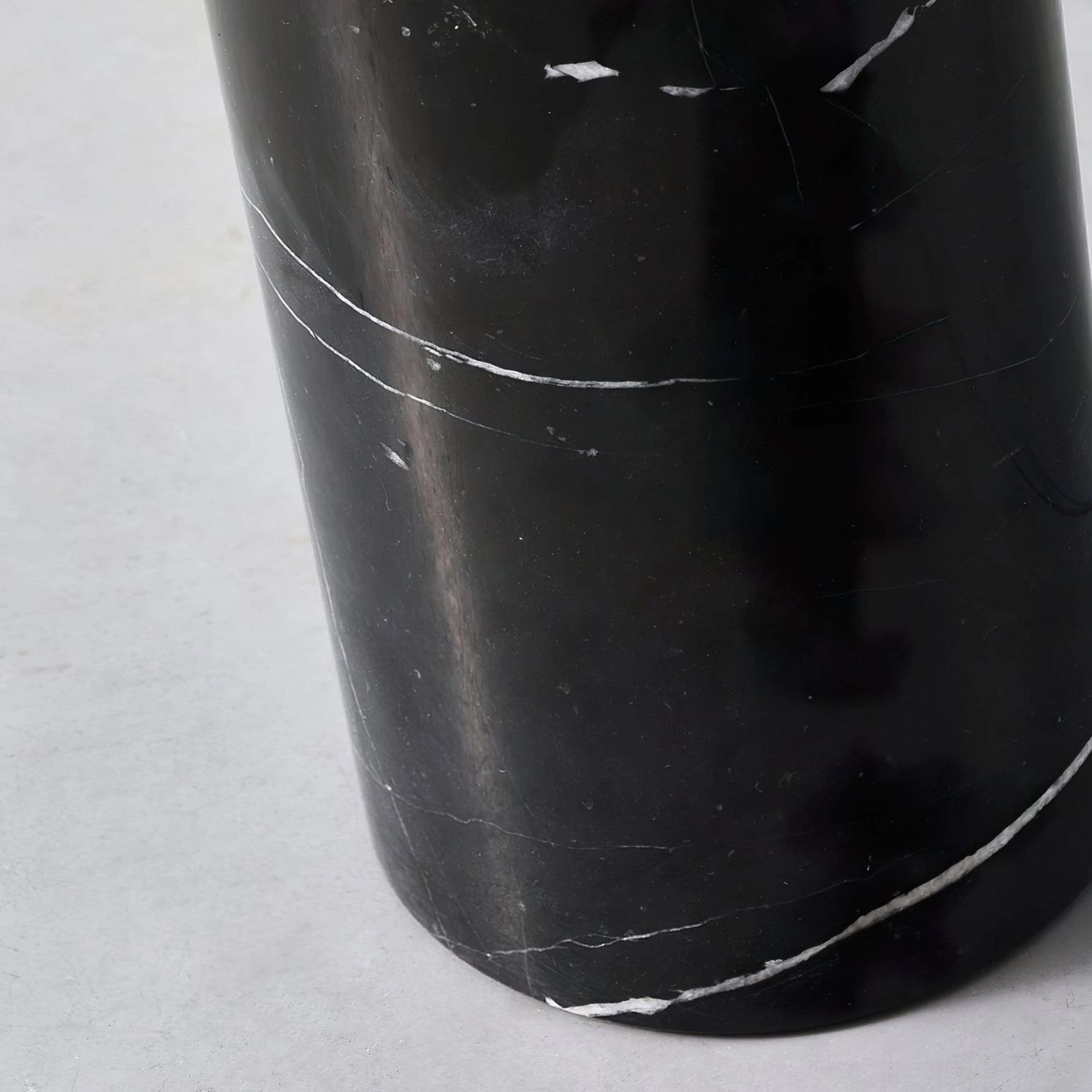 Close-up detail of Filo floor lamp black marble base with white veining - low-angle architectural detail shot