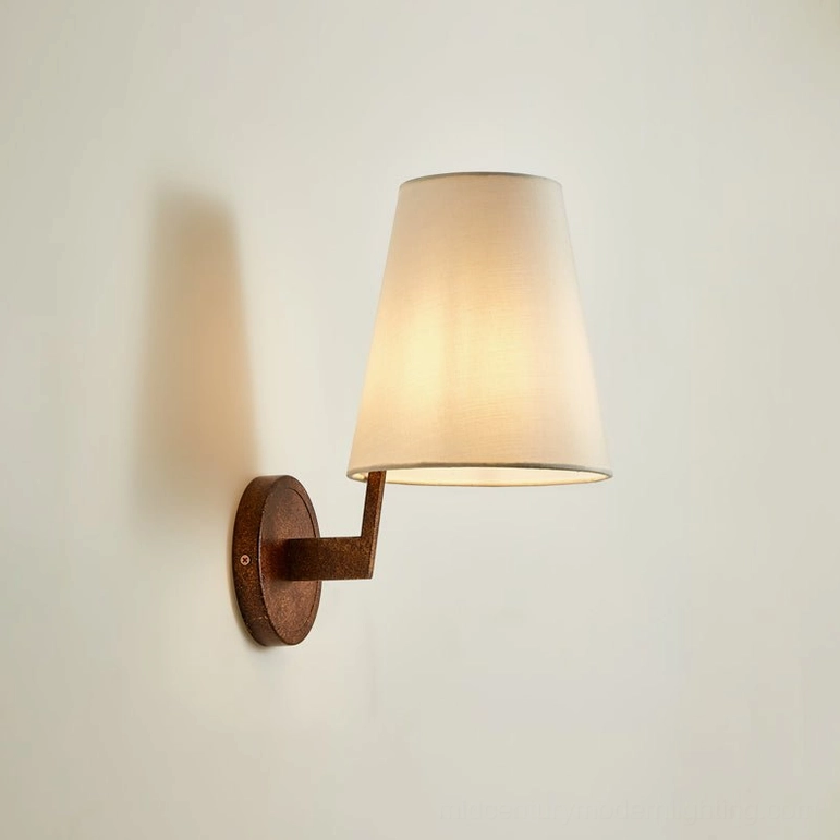 Finley wall sconce antique bronze metal mount with illuminated off-white shade, side view warm ambient glow