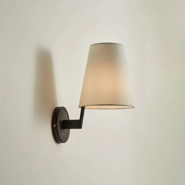 Finley mid-century modern wall sconce black finish, side view with illuminated warm light, compact tapered shade