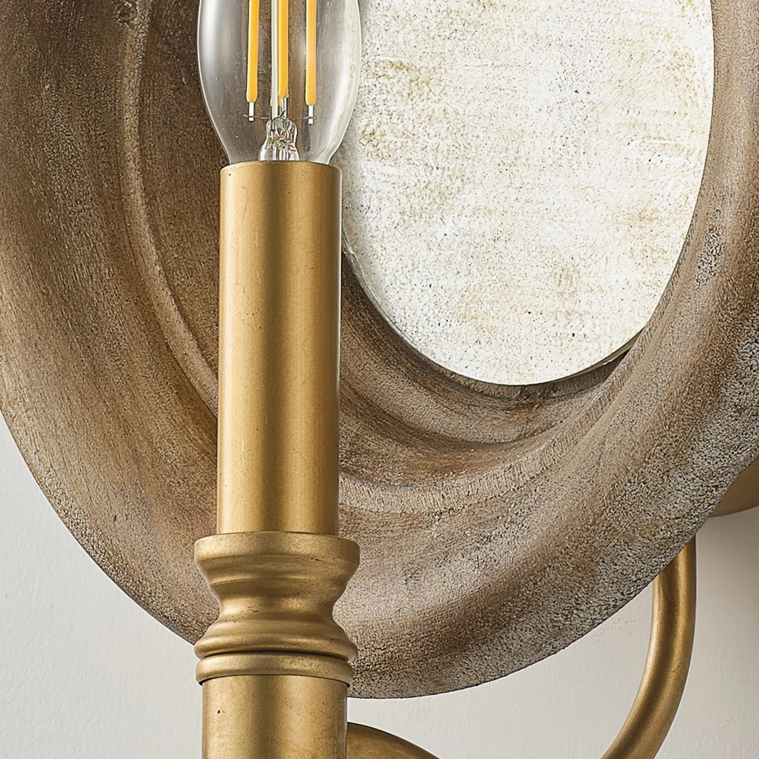 Finn wall lamp top-down view of brass lamp holder with exposed LED candle bulb and mirror backing