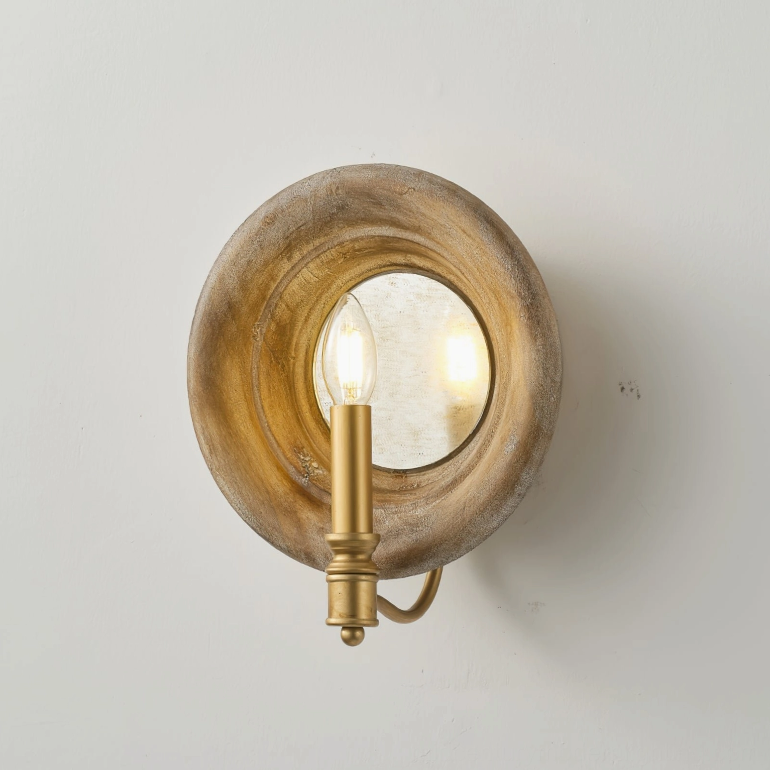Close-up detail of Finn vintage wall lamp showing lit candle bulb and reflective round mirror center