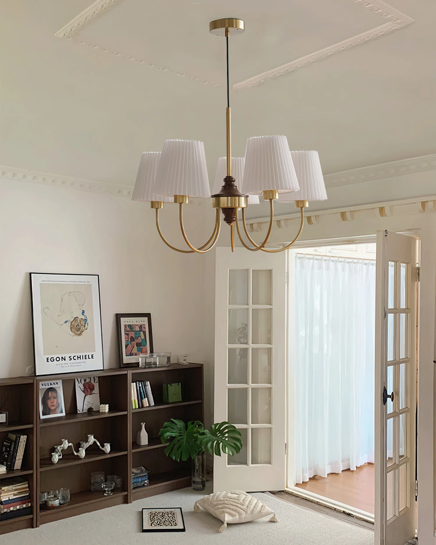 Large 5-head wood chandelier suspended in vintage living room with bookshelf and doors