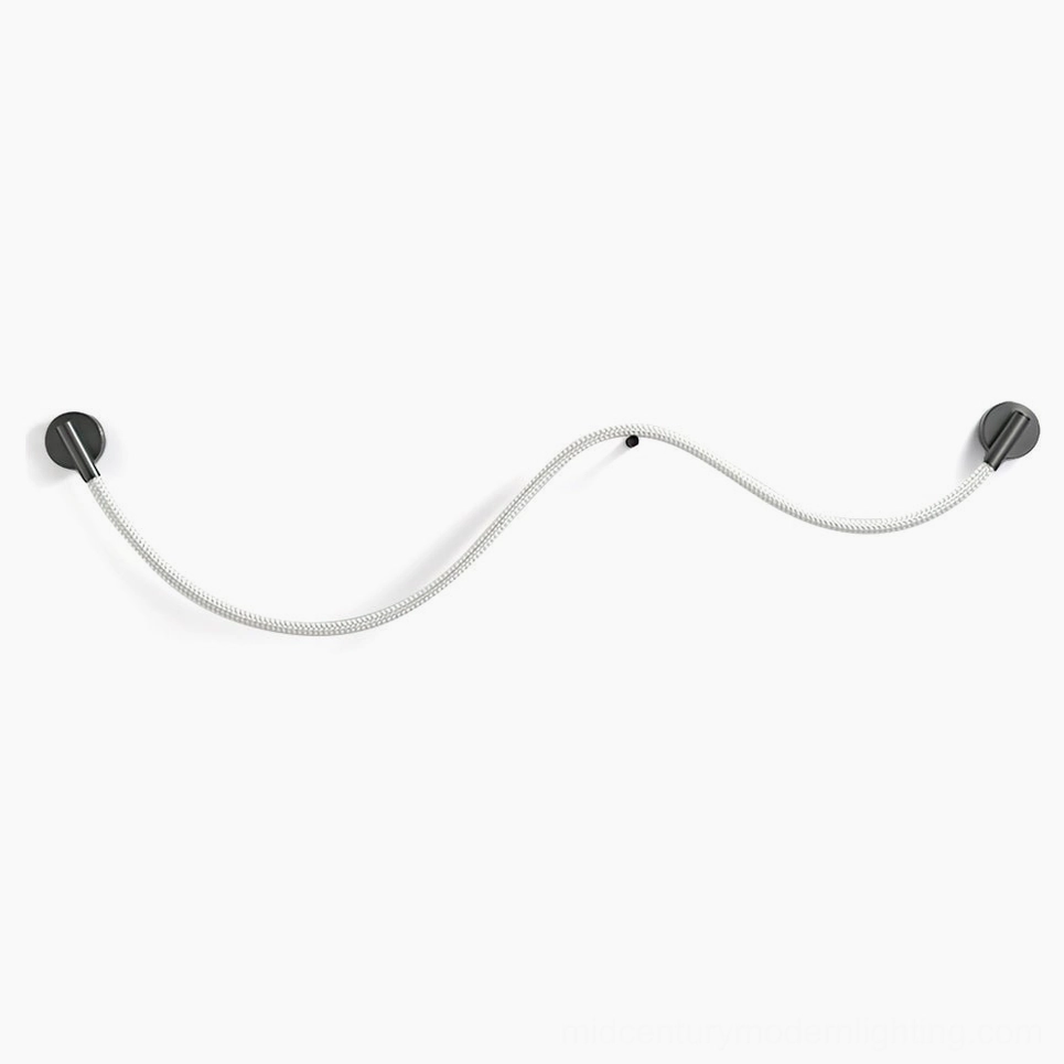 Flecto Tube flexible LED wall lamp in matte black, unlit front flat lay on white background showing woven fiber texture and metal mounting hardware