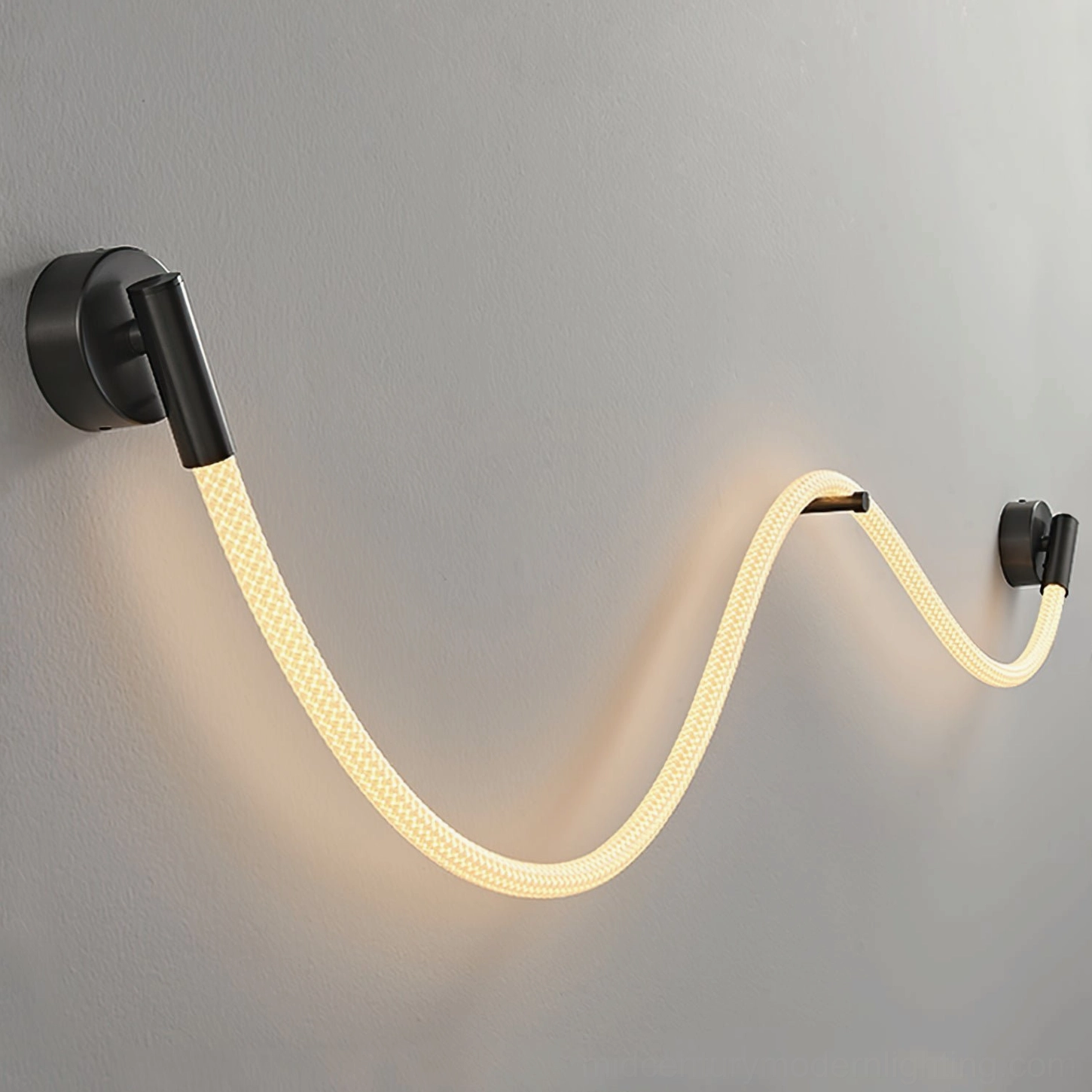 Glowing Flecto Tube LED wall lamp installed on textured grey wall showing woven rope texture and warm ambient illumination from integrated LED