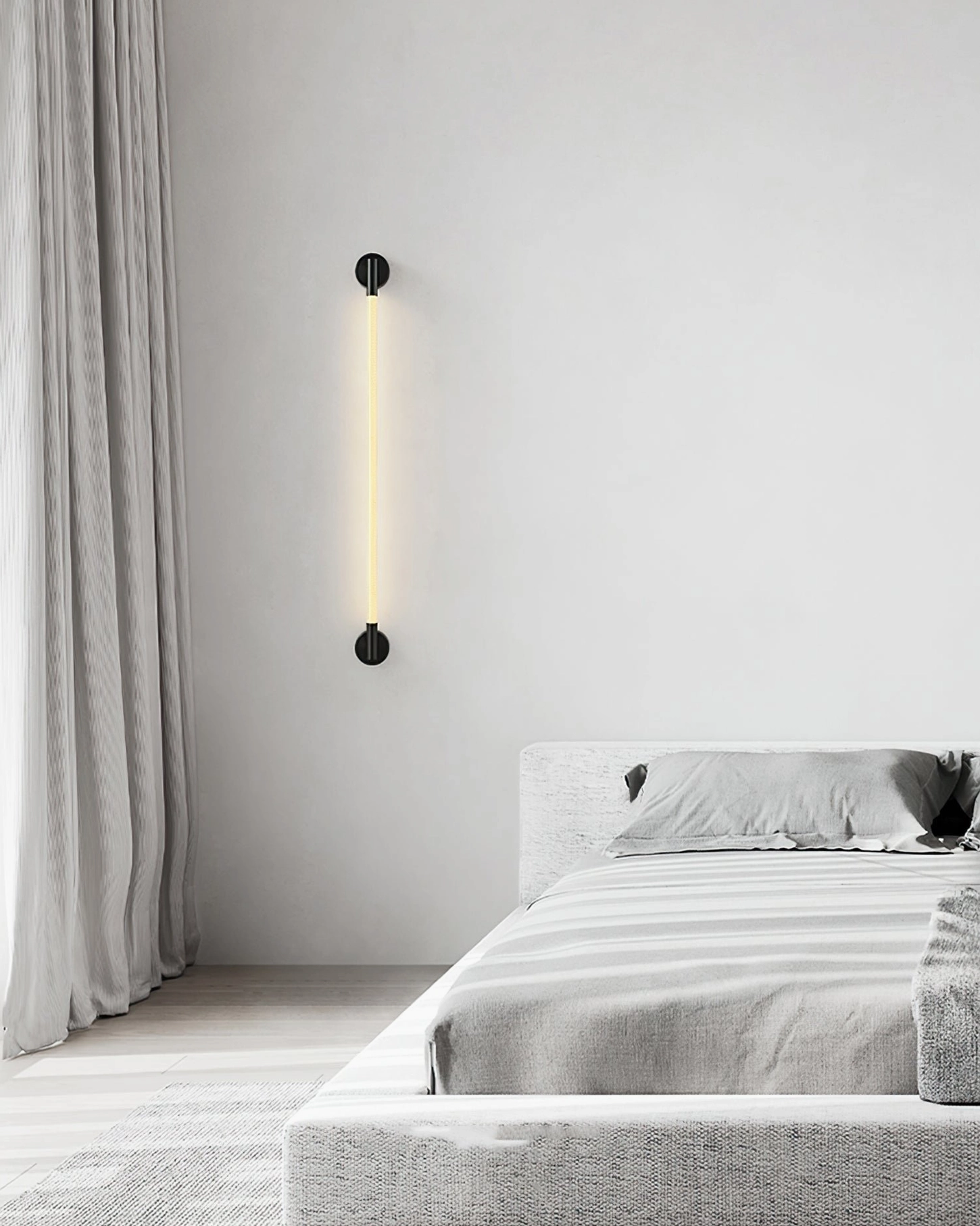 Vertical linear Flecto Tube rope wall lamp mounted in modern bedroom with warm LED glow and matte black mounting fixtures