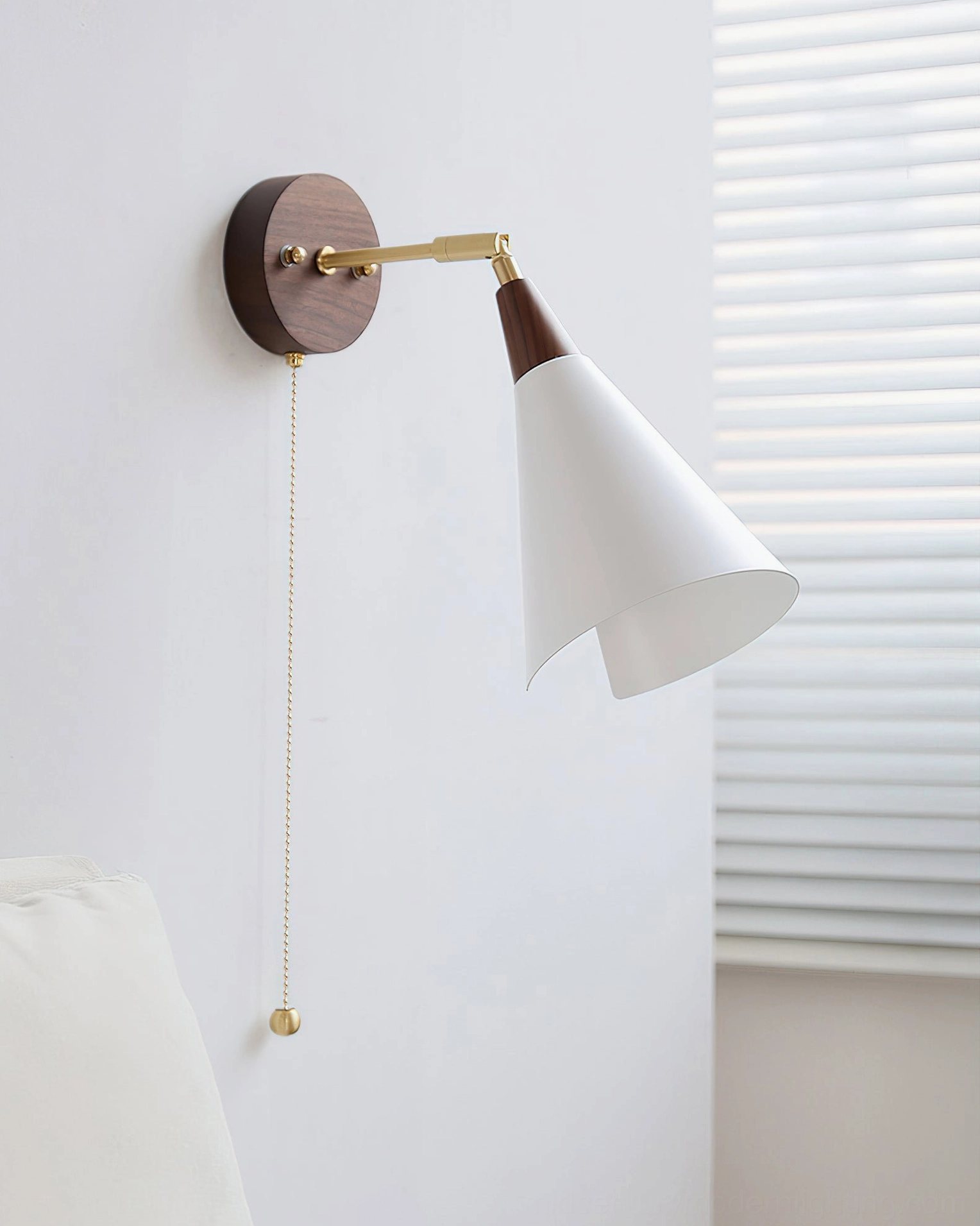 Fleka adjustable mid-century wall sconce shown at side angle with shade tilted, Nordic minimalist design with window blinds background