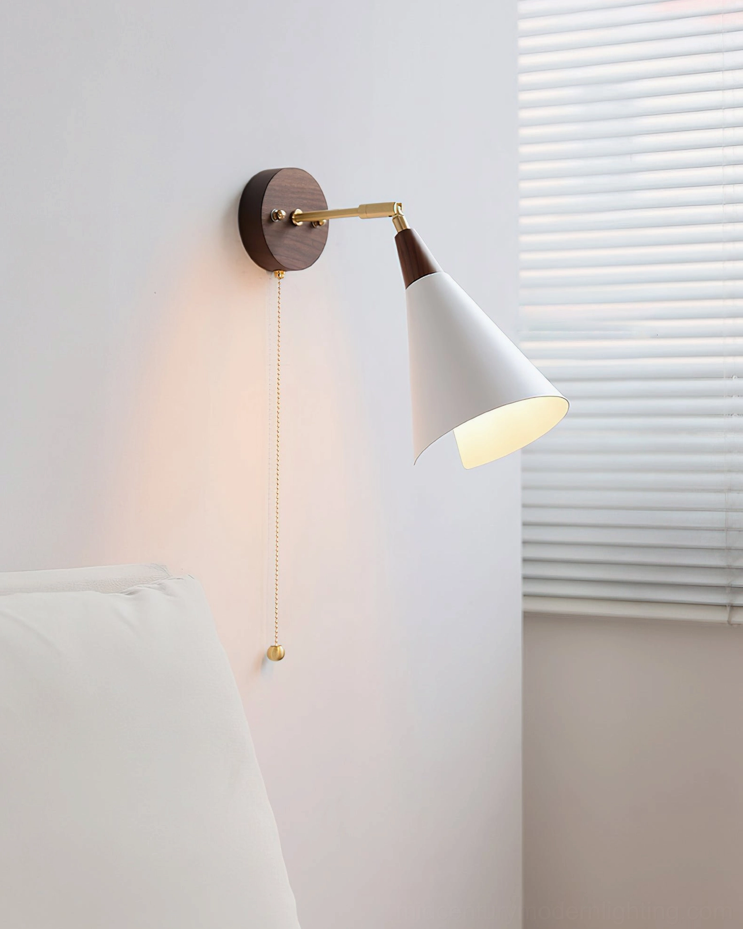 Fleka Nordic wall lamp illuminated at eye-level, showing brass metal joints and pull cord control, bedroom bedside setting
