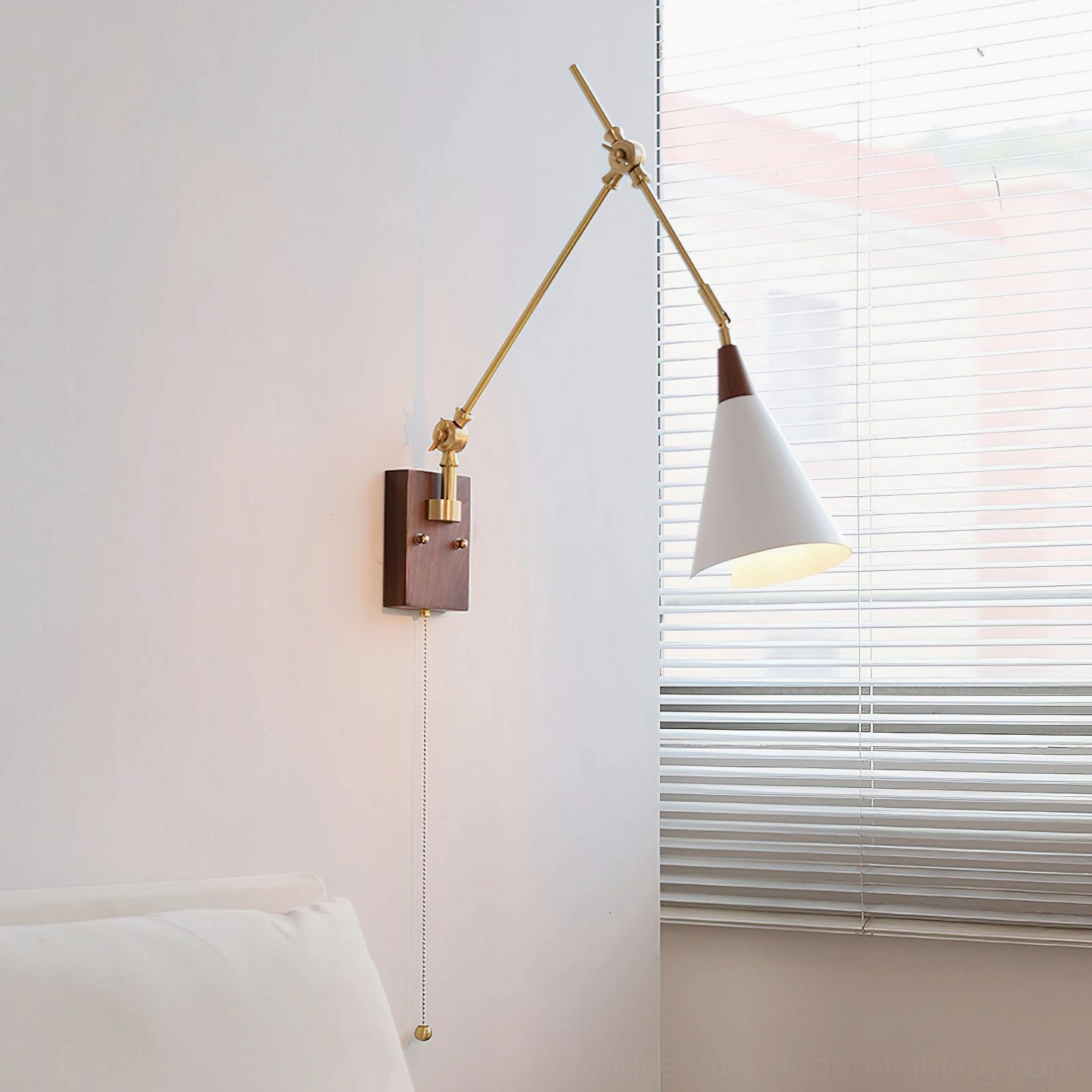 Mid-century modern swing arm wall lamp illuminated in bedroom setting showing warm light ambiance and minimalist design aesthetic