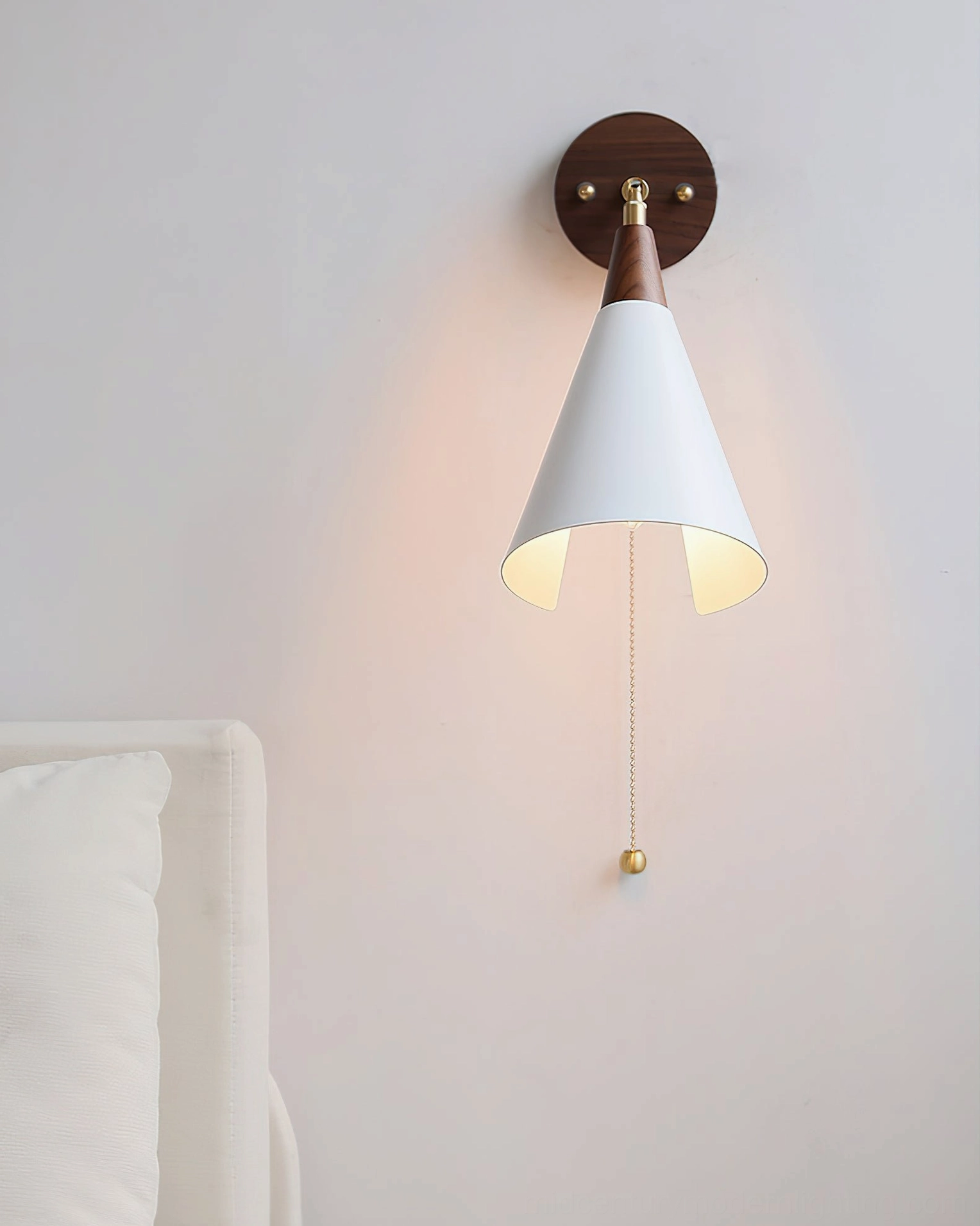 Fleka wall sconce with pull-chain cord featuring ball-end terminal, unlit conical shade, bedroom bedside installation