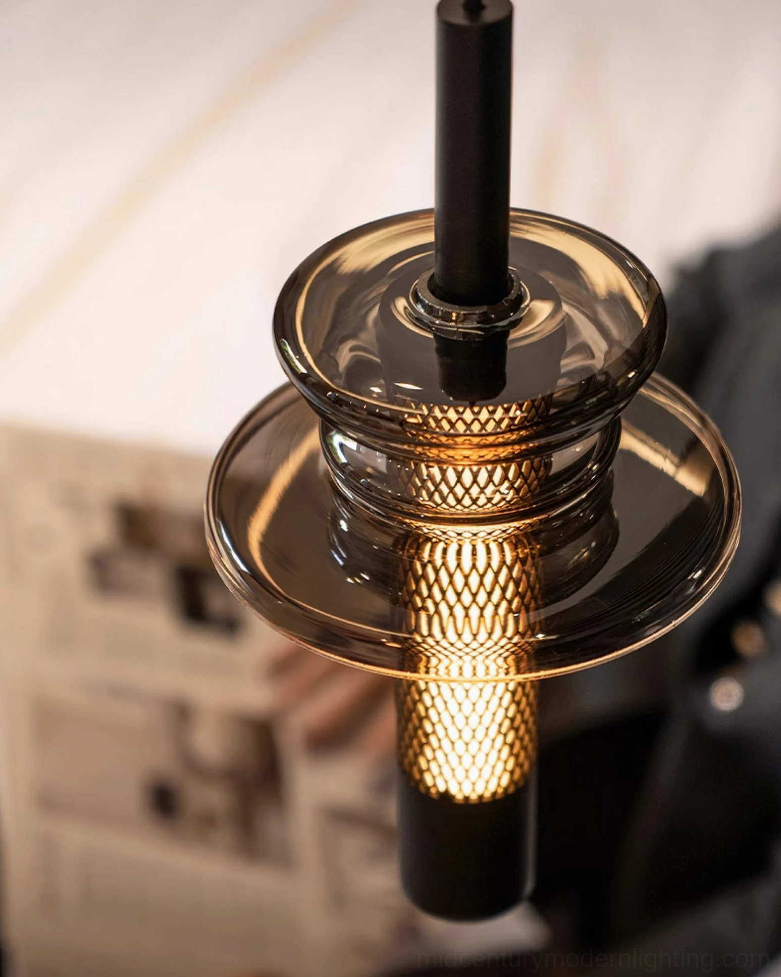 Float pendant light sculptural form with perforated metal mesh creating industrial modern aesthetic