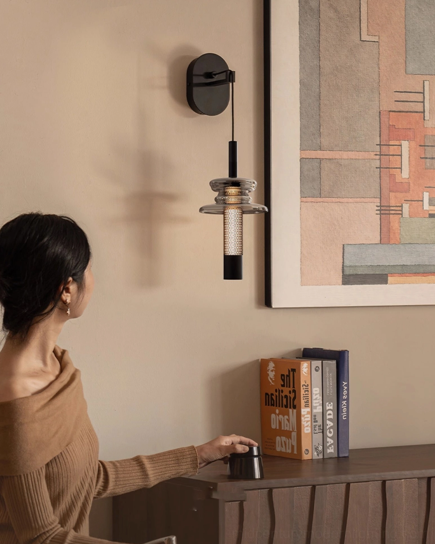 Modern wall-mounted Float light in minimalist residential reading nook with books and side table