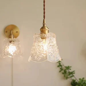 Modern floral glass pendant lamp paired with matching wall sconce in residential living room setting with warm brass fixtures