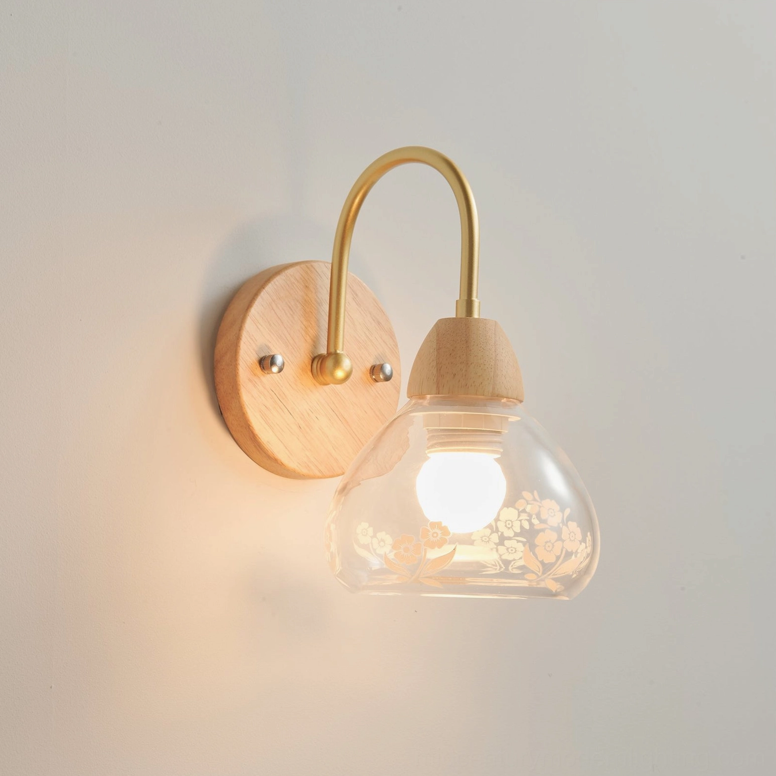 Modern wall sconce with floral glass shade creating warm ambient light