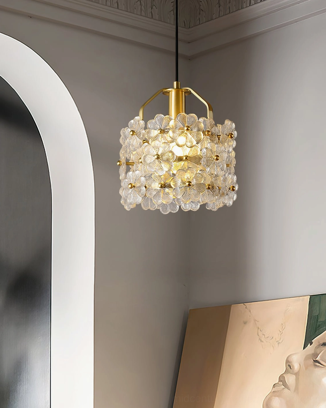 Modern botanical pendant suspended in contemporary entryway with arched doorway and abstract floor art