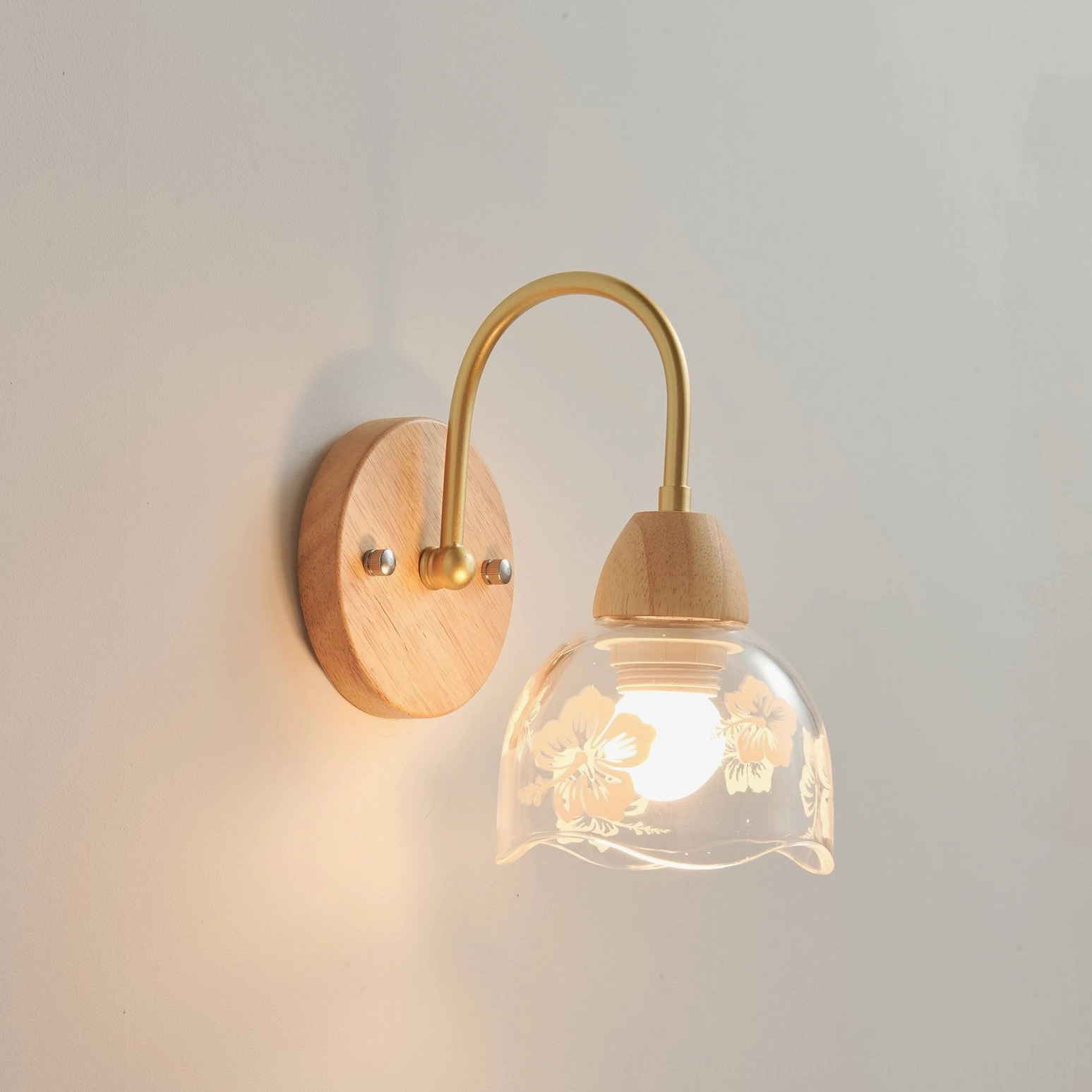 Illuminated wooden wall sconce casting soft botanical shadows on wall surface