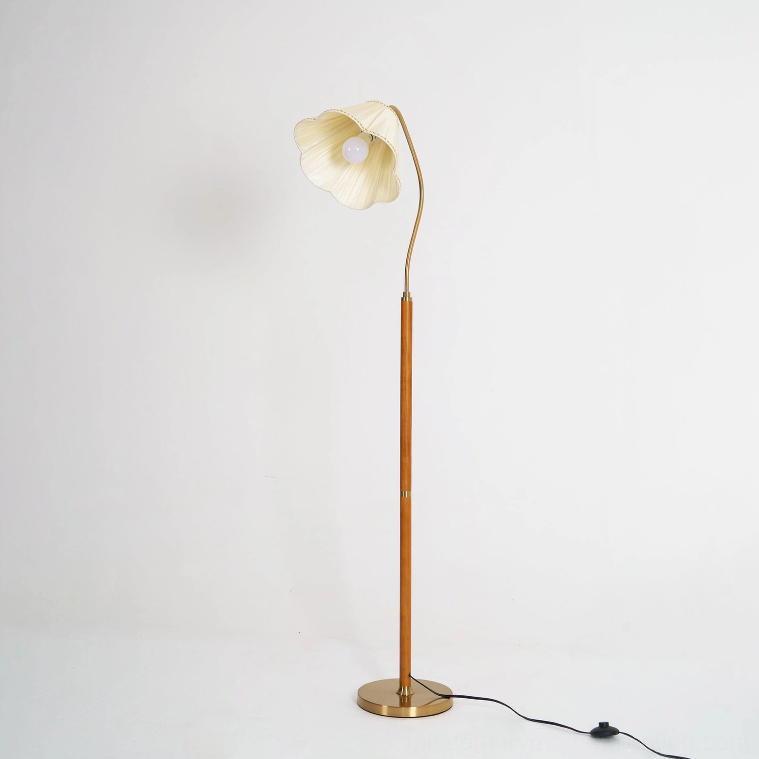 Florentine floor lamp showing visible bulb socket and polished brass base hardware on studio background