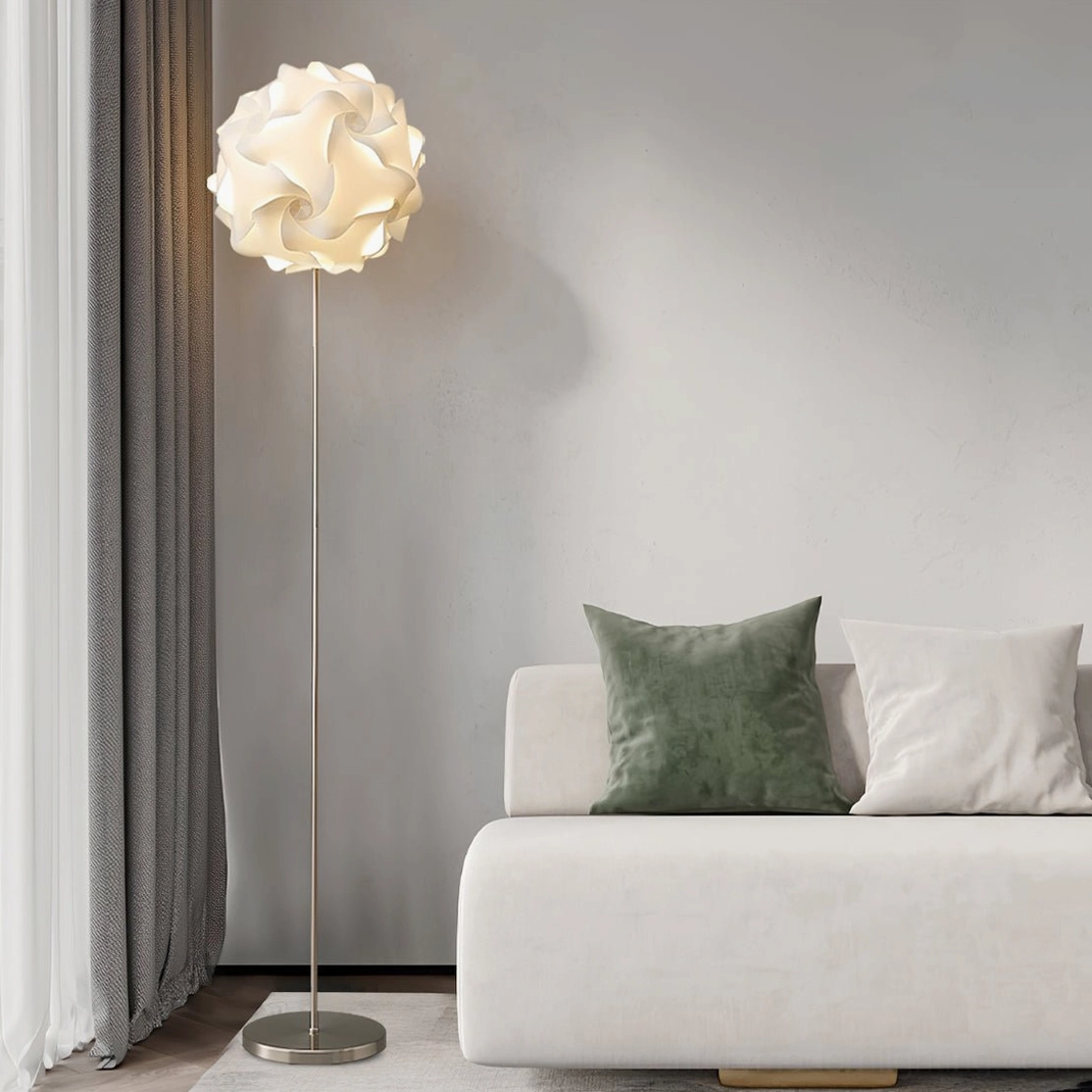 Modern flower-shaped floor lamp with soft illumination beside white sofa and gray curtains