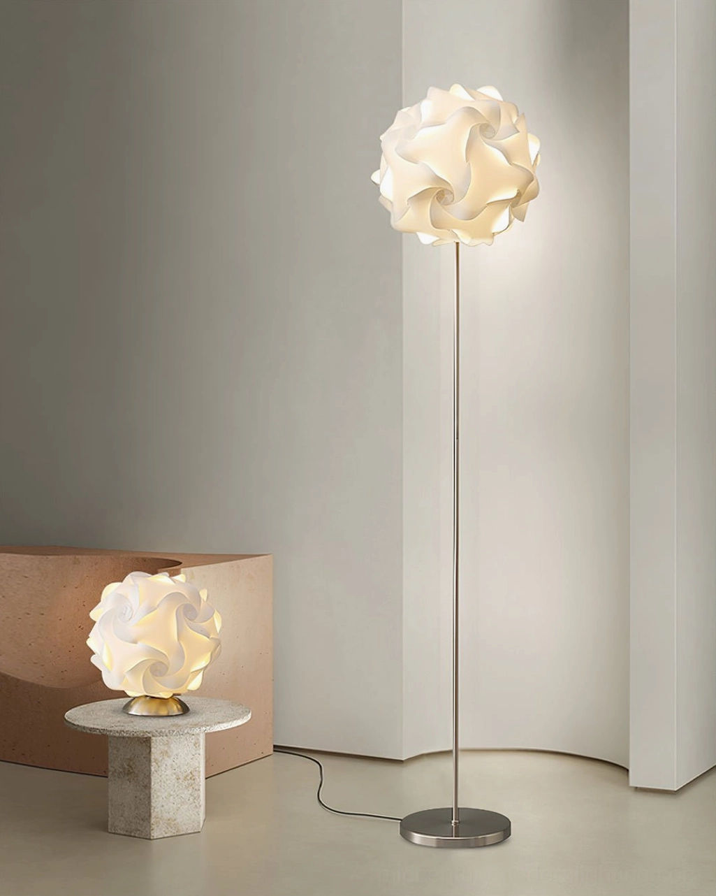 Silver metal flower floor lamp beside concrete side table in minimalist living room