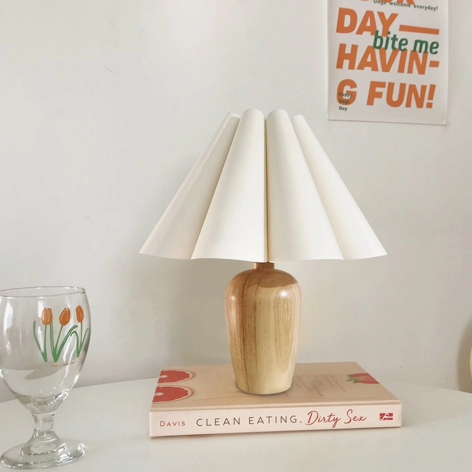 Beige fluted linen lamp front view on minimalist desk with books and glassware in contemporary home office setting