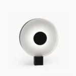 Round Flying Saucer LED table lamp with black and white matte finish, front view against minimalist studio background