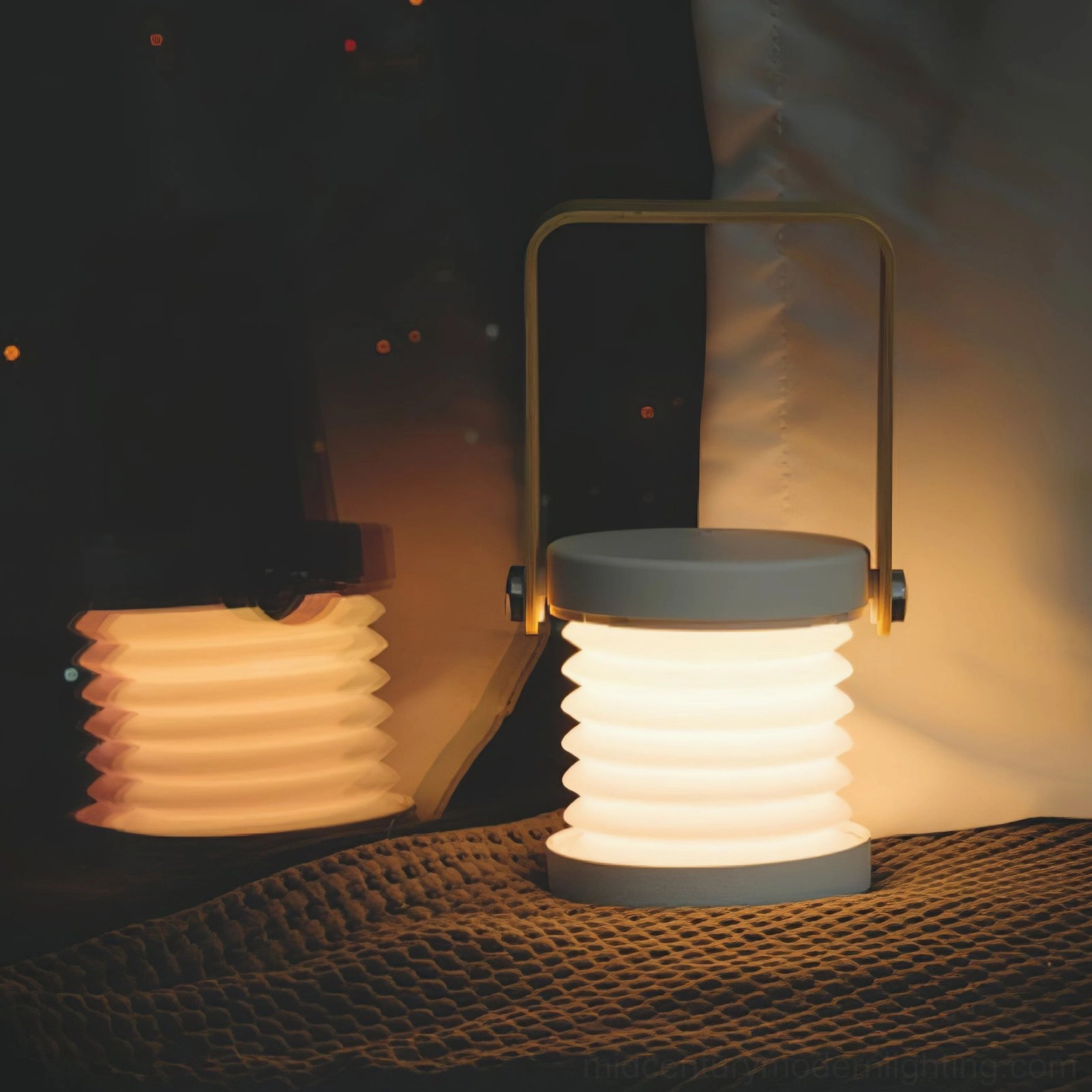 Foldable lantern table lamp in cozy bedroom setting, warm glowing light from integrated LED creating intimate atmosphere