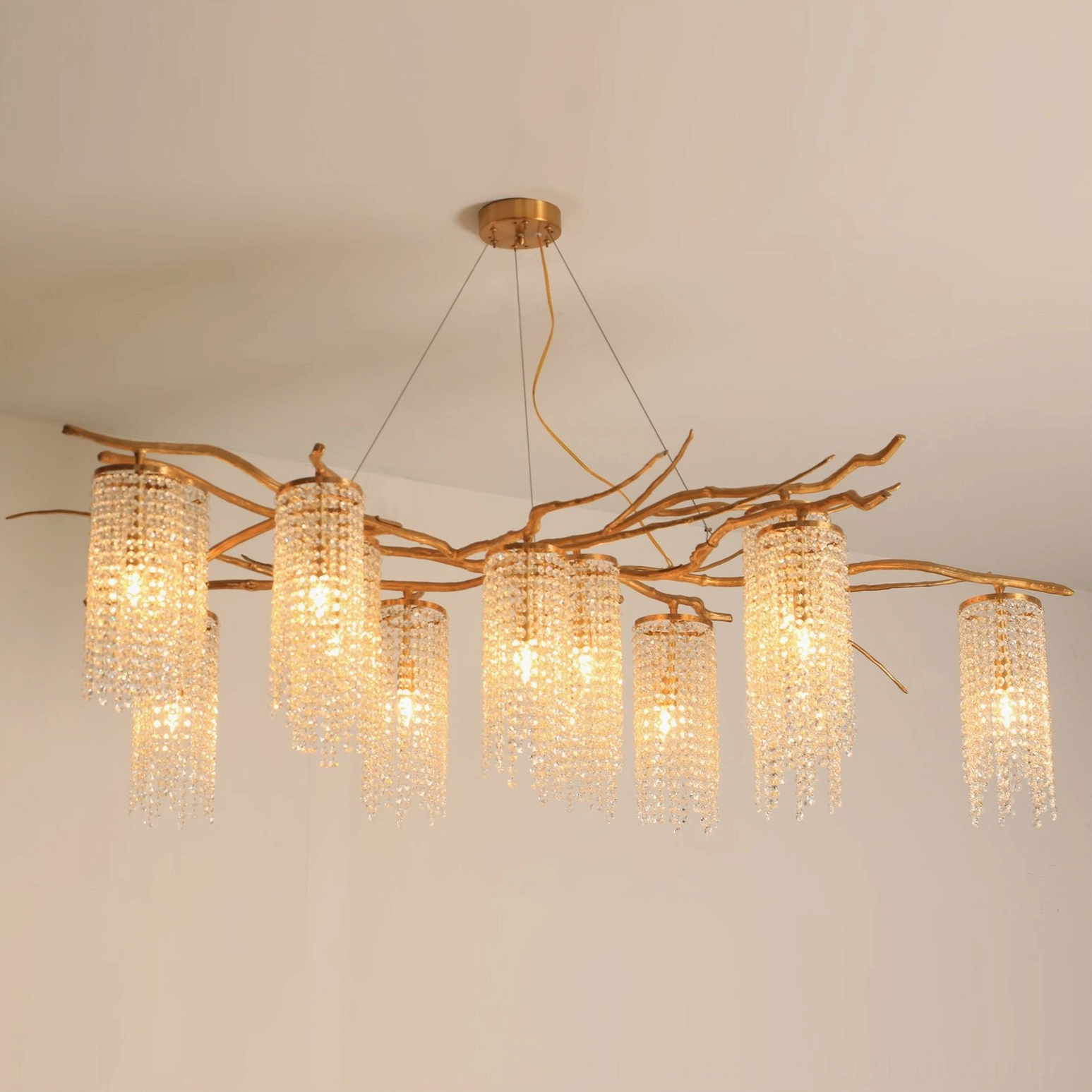 Forest Dawn Crystal Chandelier with clear crystal shades and antique brass finish under warm illuminated light