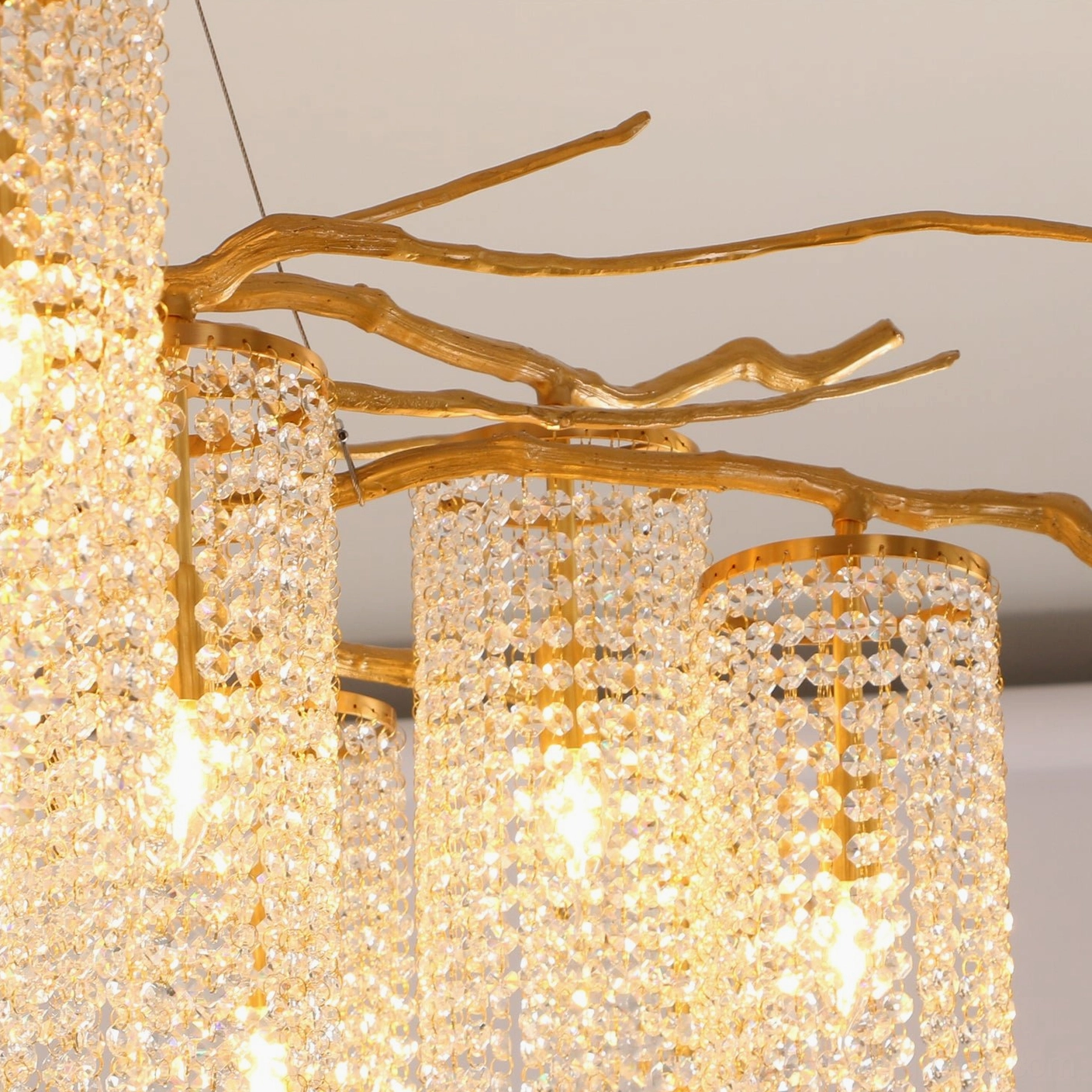 Close-up detail of Forest Dawn Chandelier showing dense crystal beads, antique gold metal branches, and warm glowing light