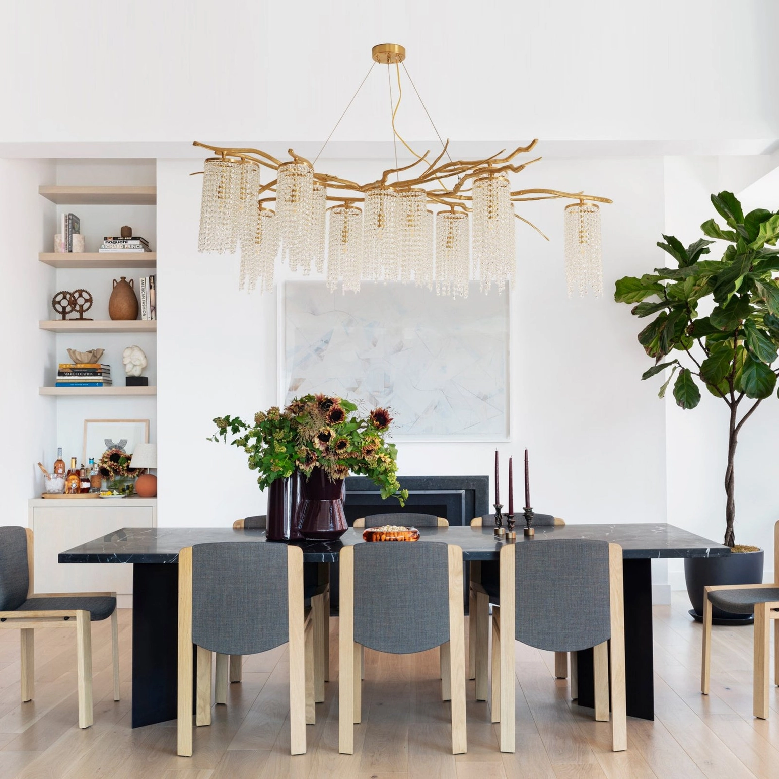 Forest Dawn Chandelier in minimalist modern dining space with lit crystal shades and neutral home decor