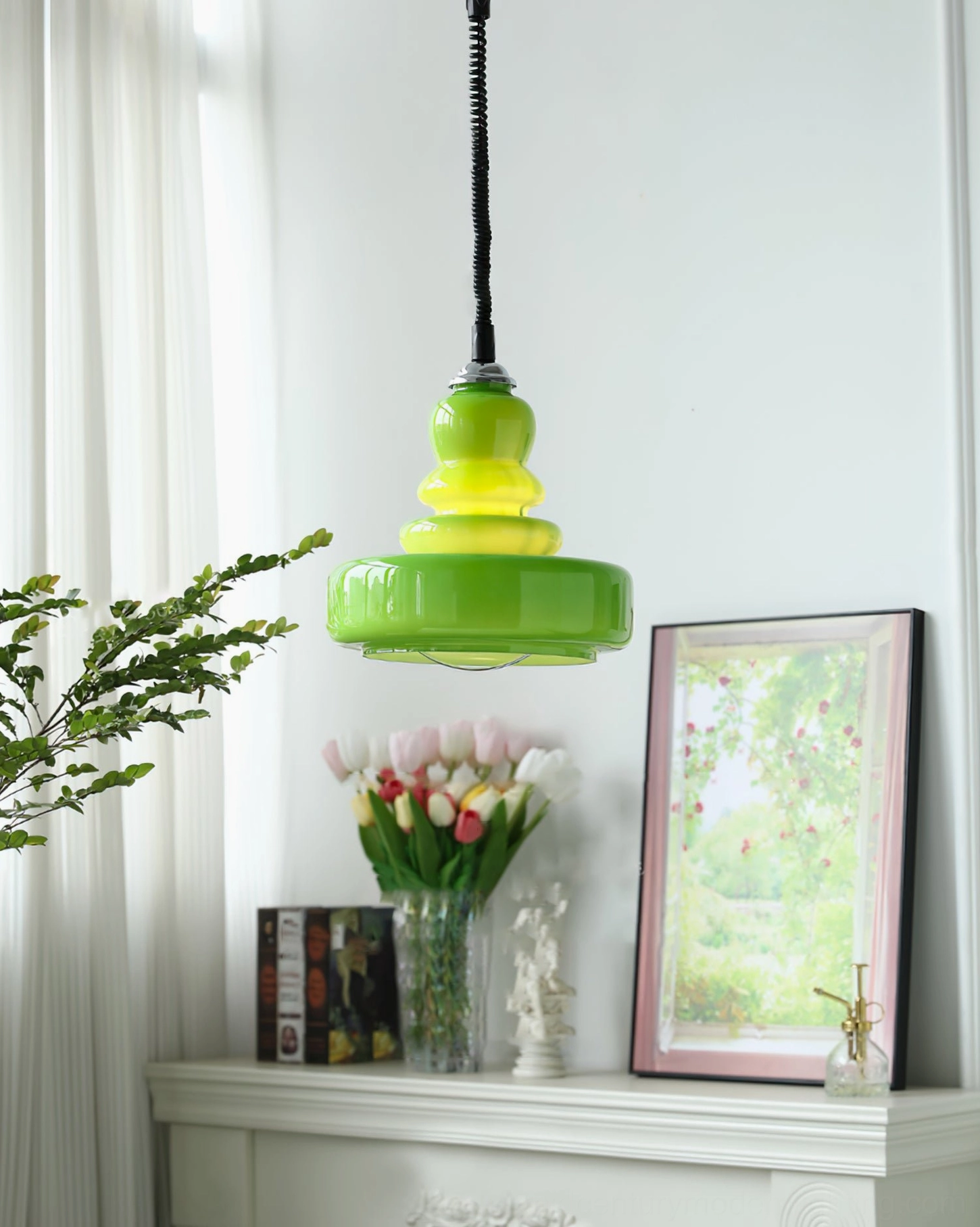 Bright forest green tiered gourd glass pendant light in minimalist interior with curtains and potted plants