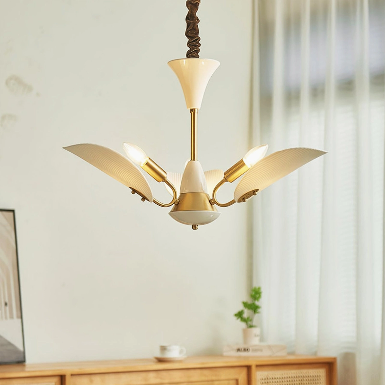 Franco ceramic petal chandelier side view with brass accents and pleated ceramic shades in dining area