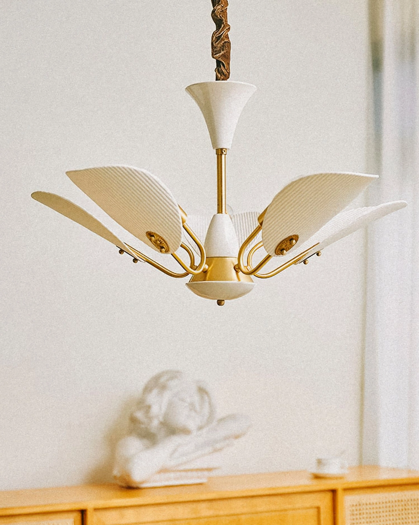 Franco ceramic chandelier with twisted hanging cord and symmetrical petal design in vintage interior