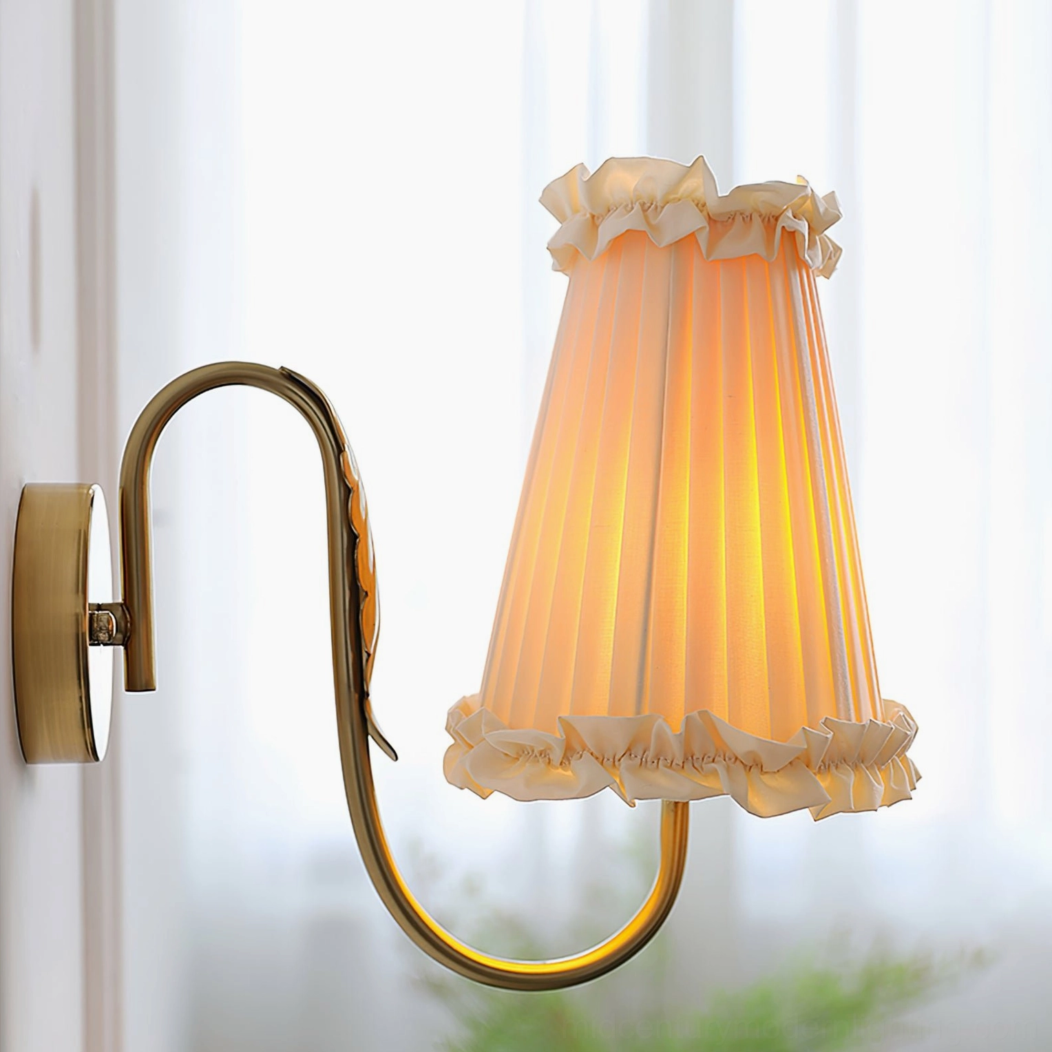 French pleated beige wall sconce with brass gold hardware positioned in home interior with landscape painting