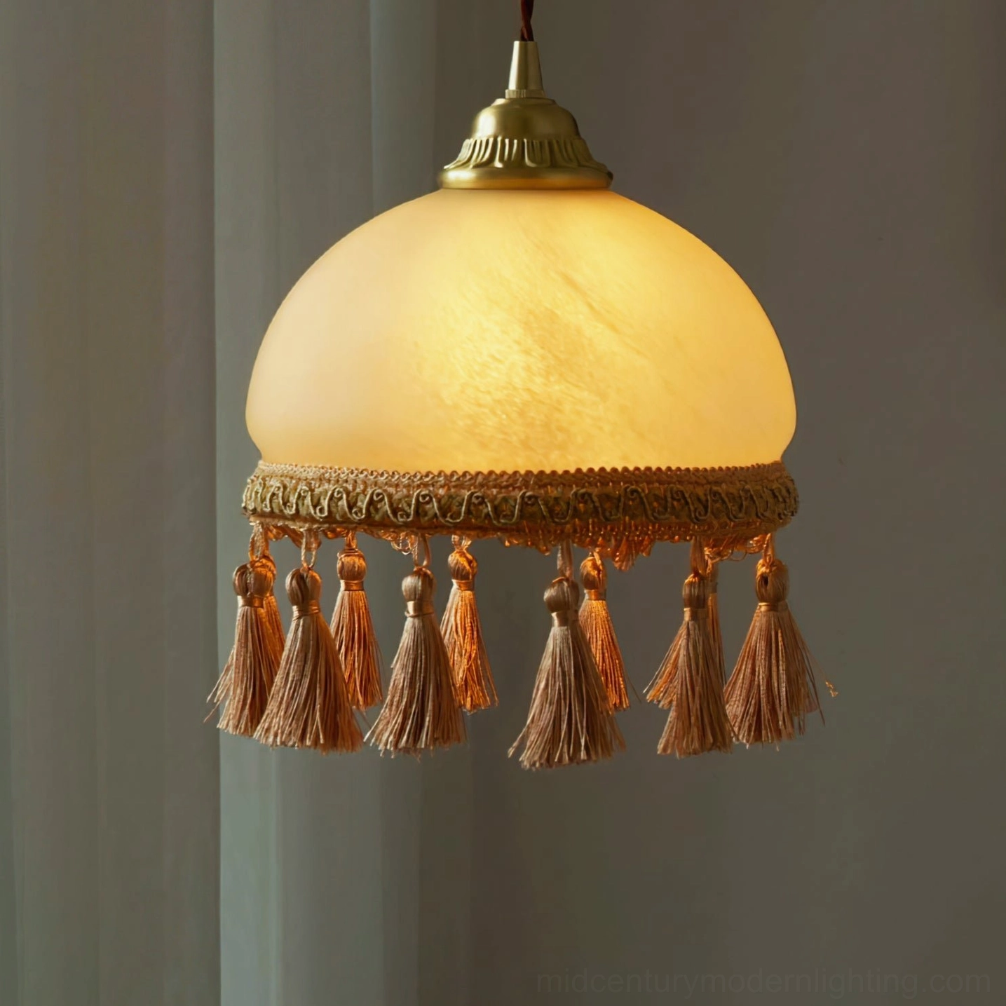 French tassel brass pendant light highlighting polished brass finish and fabric tassel construction