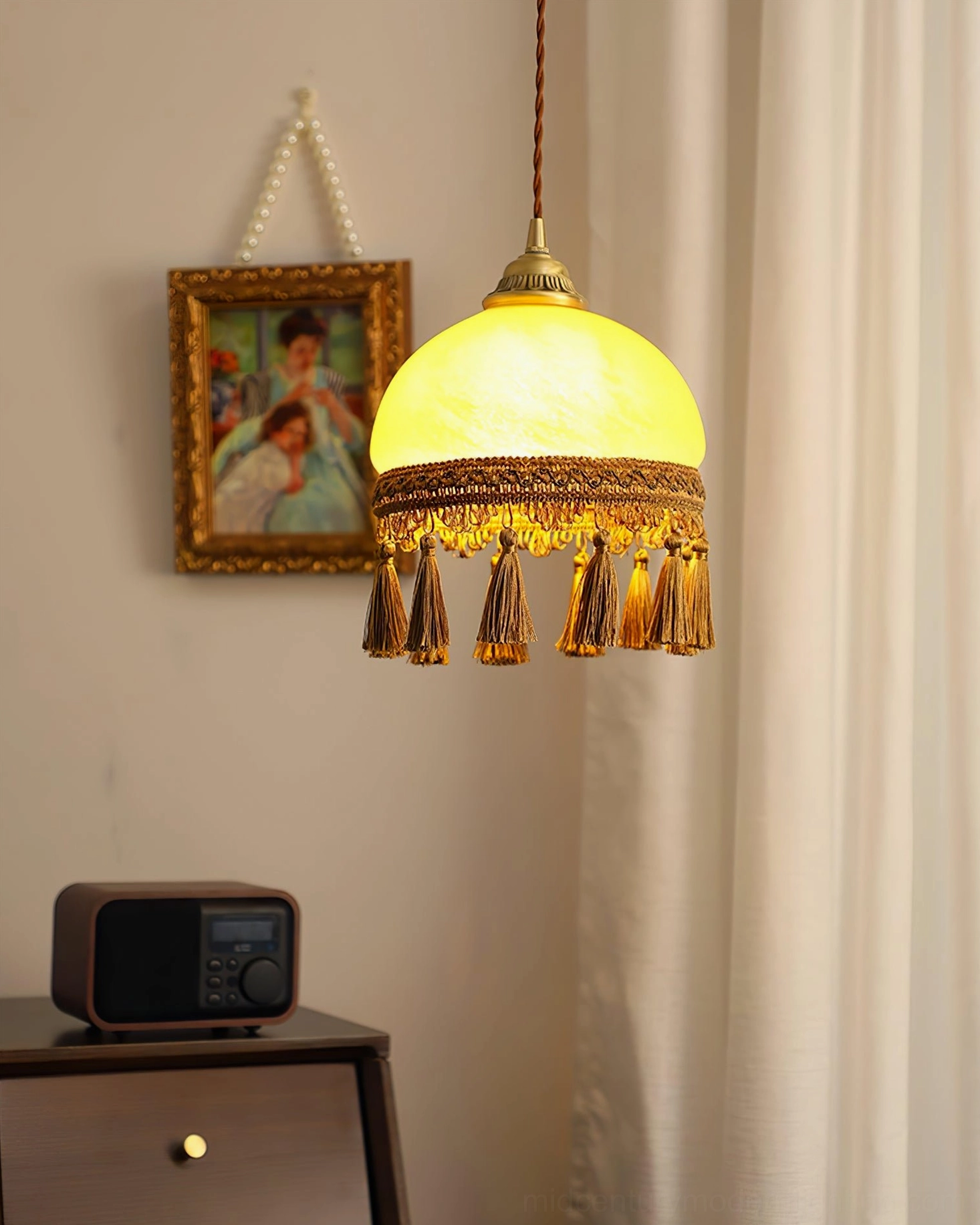 French tassel brass pendant light with beige glass diffuser displaying warm ambient light quality